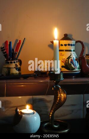 Candle lights on an old tiled mantlepiece at christmas Stock Photo