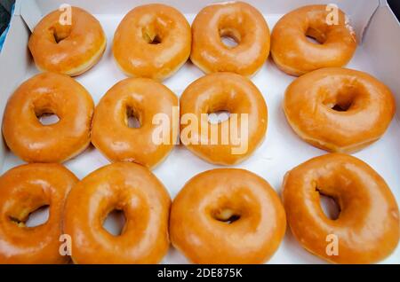 An open box of a dozen original glazed Krispy Kreme doughnuts is pictured at Krispy Kreme Doughnuts, Nov. 28, 2020, in Ocean Springs, Mississippi. Stock Photo