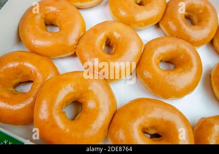 An open box of a dozen original glazed Krispy Kreme doughnuts is pictured at Krispy Kreme Doughnuts, Nov. 28, 2020, in Ocean Springs, Mississippi. Stock Photo
