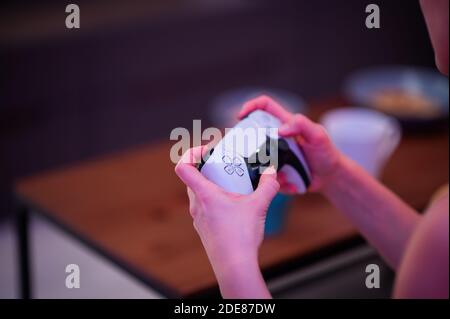 Girl with next gen controller in her hands playing games at home. Stock Photo