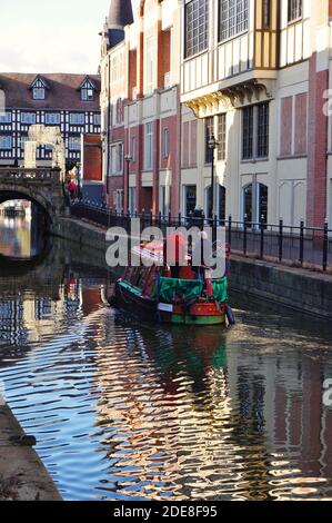 People riding on a green barge cruising along the river Witham in the city Stock Photo