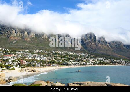 Glen Beach and Camps Bay Beach in Cape Town, South Africa with Twelve Apostles covered by clouds behind. Beach in South Africa. Stock Photo