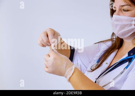 The medicine gloves doctor holding an ampoule for vaccination treatment in his hand focus on the ampoule Stock Photo