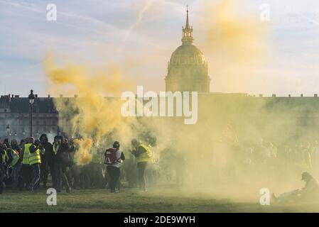 Protesters take shelter from the police on the Invalides esplanade, drowned in a cloud of yellow smoke from the smoke. Several thousand people gathered to demonstrate during act 14 of the protest movement against the rise in the cost of living, taxes and fuel, yellow jackets (Gilets Jaunes). The Parisian course took place between the Champs-Elysées and the Place des Invalides in relative calm. There were some clashes between demonstrators and the police, who used tear gas. Paris, France, February 16, 2019. Photo by Samuel Boivin / ABACAPRESS.COM Stock Photo