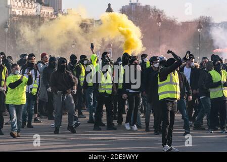 Protesters take shelter from the police on the Invalides esplanade, drowned in a cloud of yellow smoke from the smoke. Several thousand people gathered to demonstrate during act 14 of the protest movement against the rise in the cost of living, taxes and fuel, yellow jackets (Gilets Jaunes). The Parisian course took place between the Champs-Elysées and the Place des Invalides in relative calm. There were some clashes between demonstrators and the police, who used tear gas. Paris, France, February 16, 2019. Photo by Samuel Boivin / ABACAPRESS.COM Stock Photo