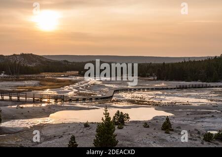 A hazy sunset over the Porcelain Basin in the Norris Geyser Basin in Yellowstone National Park, Wyoming, USA. Stock Photo