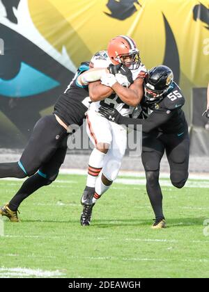 Jacksonville, FL, USA. 29th Nov, 2020. Cleveland Browns running back Nick Chubb (24) is tackled by Jacksonville Jaguars middle linebacker Joe Schobert (47) and Jacksonville Jaguars outside linebacker Kamalei Correa (55) during 2nd half NFL football game between the Cleveland Browns and the Jacksonville Jaguars. Cleveland defeated Jacksonville 27-25 at TIAA Bank Field in Jacksonville, Fl. Romeo T Guzman/CSM/Alamy Live News Stock Photo