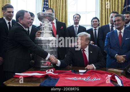 US President Donald J. Trump (2-R) shakes hands with Commissioner of the National Hockey League (NHL) Gary Bettman (L), beside the Stanley Cup, players and staff of the NHL 2018 Stanley Cup Champions, the Washington Capitals; in the Oval Office of the White House in Washington, DC, USA, 25 March 2019. Also in the picture is Capitals owner Ted Leonsis (Front R). Photo by Michael Reynolds/pool/ABACAPRESS.COM Stock Photo