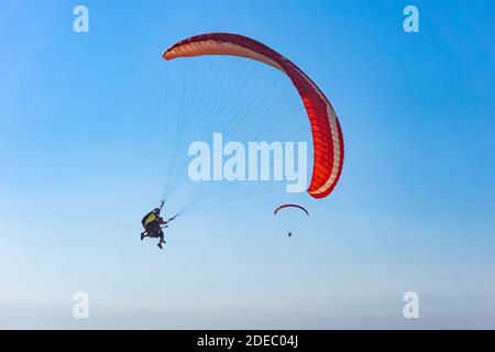 Paragliding in the sky. Paraglider tandem flying over the sea with mountains at sunset. Oludeniz, Babadag, Fethiye. Stock Photo