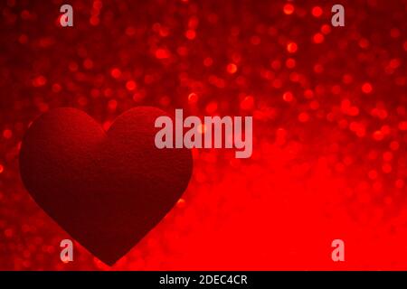 Love background. Red heart shape isolated on blurred red lights. Valentine's Day decoration. Stock Photo