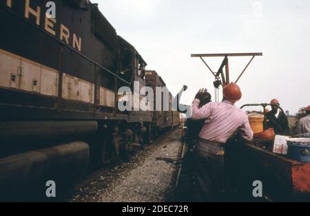 Southern Railway right-of-way work crew; stops work to let a train pass on parallel tracks.  ca. 1974 Stock Photo