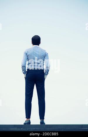 Rear view of man standing outdoors Stock Photo
