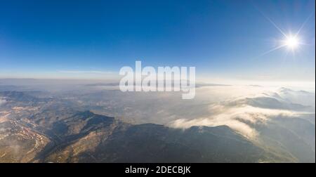 Panoramic aerial drone view of fogs over mountain in Montserrat Barcelona in morning Stock Photo