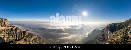 Panoramic aerial drone view of fogs over mountain in Montserrat Barcelona in morning Stock Photo