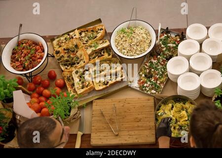 Dinner buffet table laid out with an assortment of food at an evening event Stock Photo