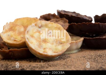 Chocolate coated hazelnut and rice florentines covered in cocoa powder.  White, milk and dark chocolate selection Stock Photo