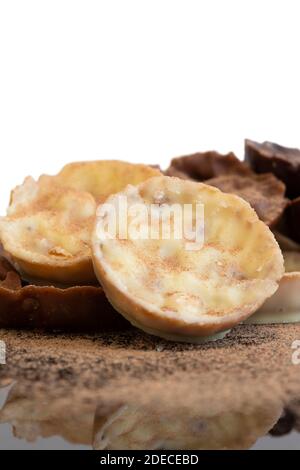 Chocolate coated hazelnut and rice florentines covered in cocoa powder.  White, milk and dark chocolate selection Stock Photo