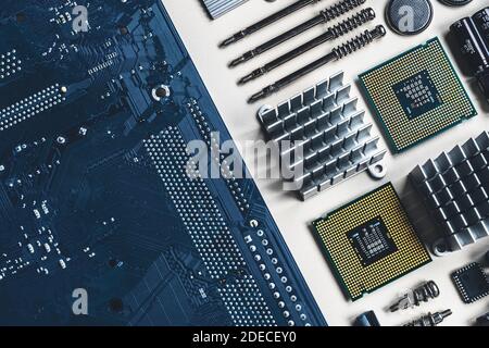 Top view of computer parts with CPU, fan cooler, battery, capacitors, radiator, chip, screwdrivers on white table background with copy space. DIY constructor concept Stock Photo