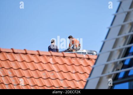 Urk, The Netherlands - June 15, 2020: Two men drink coffee on the roof. Construction, roofer or carpenter. Roof installation work. The Netherlands. Stock Photo