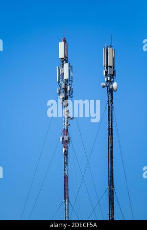 Technology of telecommunication GSM 5G,4G,3G tower. Cellular phone antennas on a building roof. Receiving transmitting Stock Photo