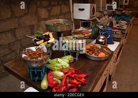 Rustic style buffet table laid out with an assortment of food at an evening event Stock Photo