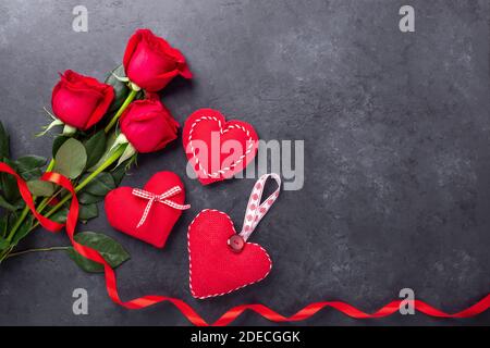 Valentines day greeting card. Red roses and textile hearts on stone background. Top view - Image Stock Photo