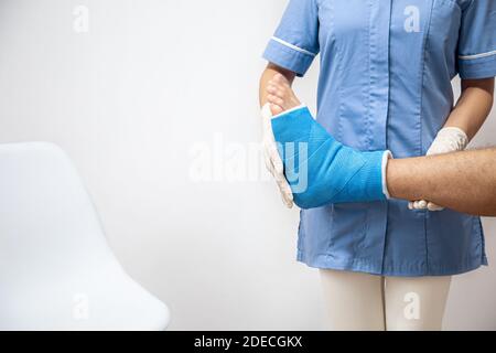 Close up of a man's leg in a cast and a blue splint after bandaging in a hospital. Stock Photo