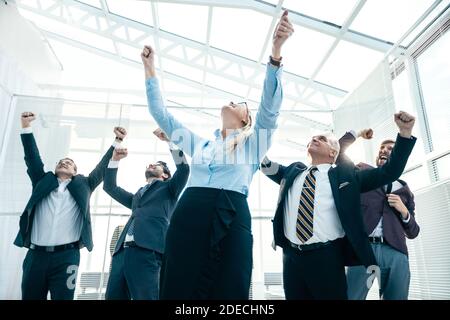 jubilant business woman standing in front of her colleagues Stock Photo