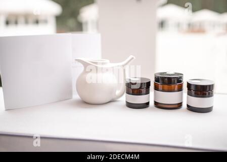 Composition of a glass bottles with empty stickers to copy paste and teapot on the white background Stock Photo