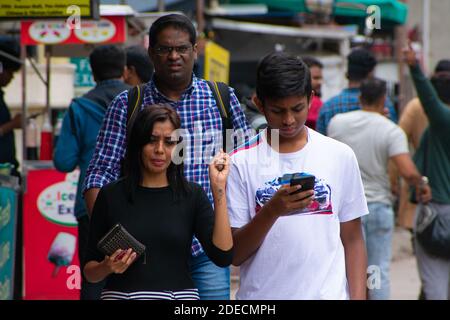 Bangalore, India - August 12, 2018: Mother and son walks together on pedestrian sideways at Brigade Road. Stock Photo