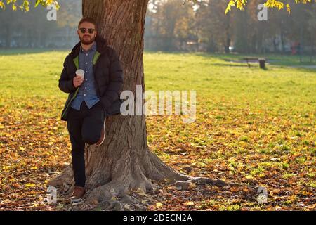 Portrait of handsome young man in park -  autumn scenery Stock Photo
