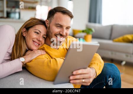Couple in love hugging and using tablet together. Stock Photo