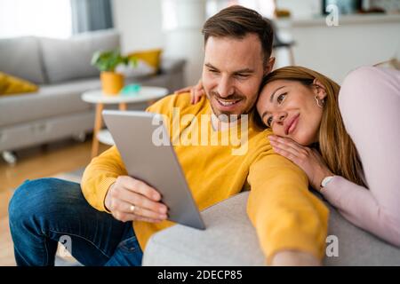 Happy cheerful couple in love using digital tablet at home Stock Photo