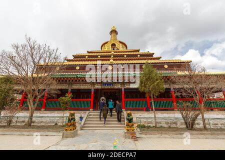 Xiahe, Gansu Province / China - April 28, 2017: Front view of Gongtang Pagoda at Labrang Monastery. Temple building with richly ornamented rooftop. Stock Photo