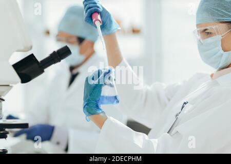 close up. female scientist examining a liquid in a laboratory flask . Stock Photo