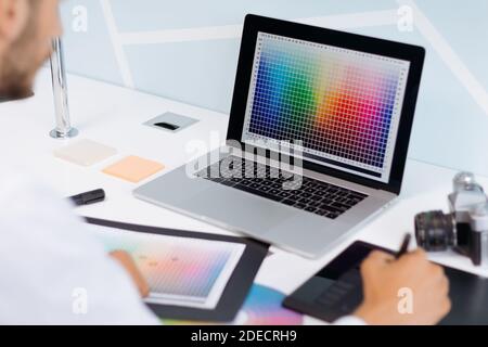 male designer using a graphics tablet and a laptop . Stock Photo
