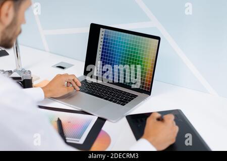 designer works on a computer and a graphic tablet at the same time. Stock Photo