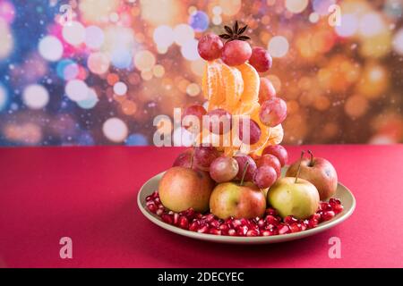 Alternative to The Christmas tree vegan tree made of fruit on a colored background . Stock Photo
