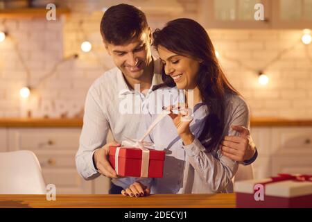Young pretty woman unpacking holiday gift from her loving boyfriend or husband Stock Photo