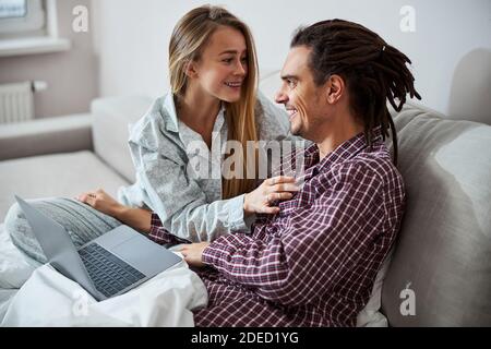 Happy young couple lying on couch at home Stock Photo