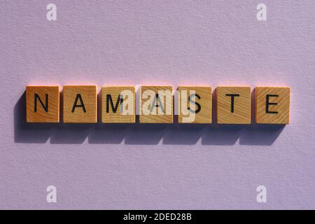 Namaste, word in wooden alphabet letters isolated on purple background Stock Photo