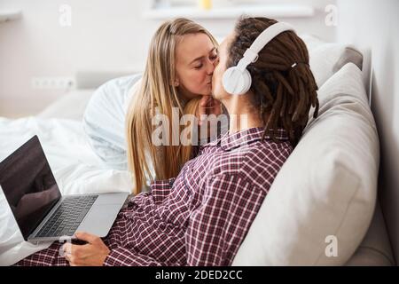 Beautiful happy couple kissing in bedroom at home Stock Photo