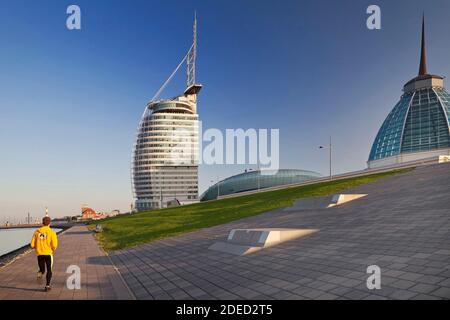 Jogger with Atlantic Hotel Sail City, Klimahaus and Mediterraneo, Germany, Bremen, Bremerhaven Stock Photo