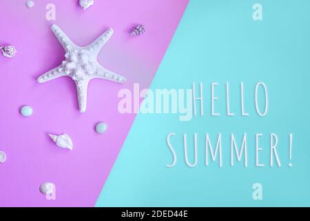 Summer flat lay on bright background. Starfish and shells as decotation. Hello Summer lettering. Stock Photo