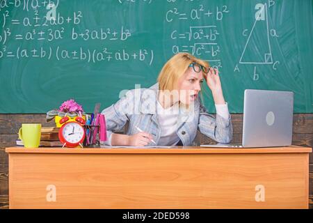Teacher shocked face keep working after classes. Teacher woman sit