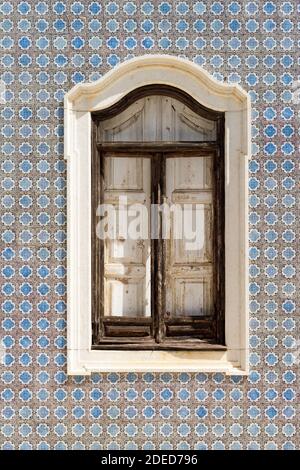 Window on a tile painted wall Stock Photo