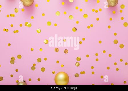 Christmas gold festive decor balls, confetti on pink background. Flat lay copy space Stock Photo