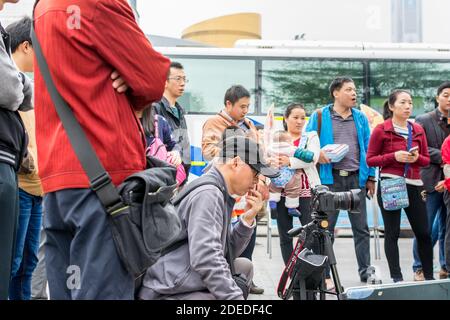 A Chinese man watching his camera and recording a man playing Chinese traditional musical instument Erhu in Shenzhen, China Stock Photo