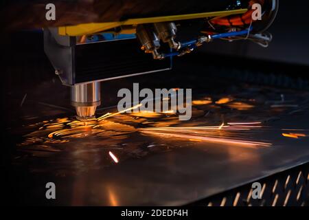 Laser cutting machine working with sheet metal with sparks in dark Stock Photo