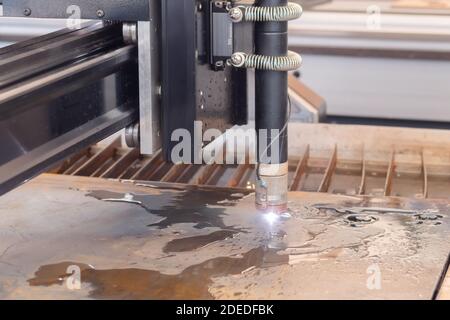 Plasma cutting machine working with sheet metal with sparks at exhibition Stock Photo
